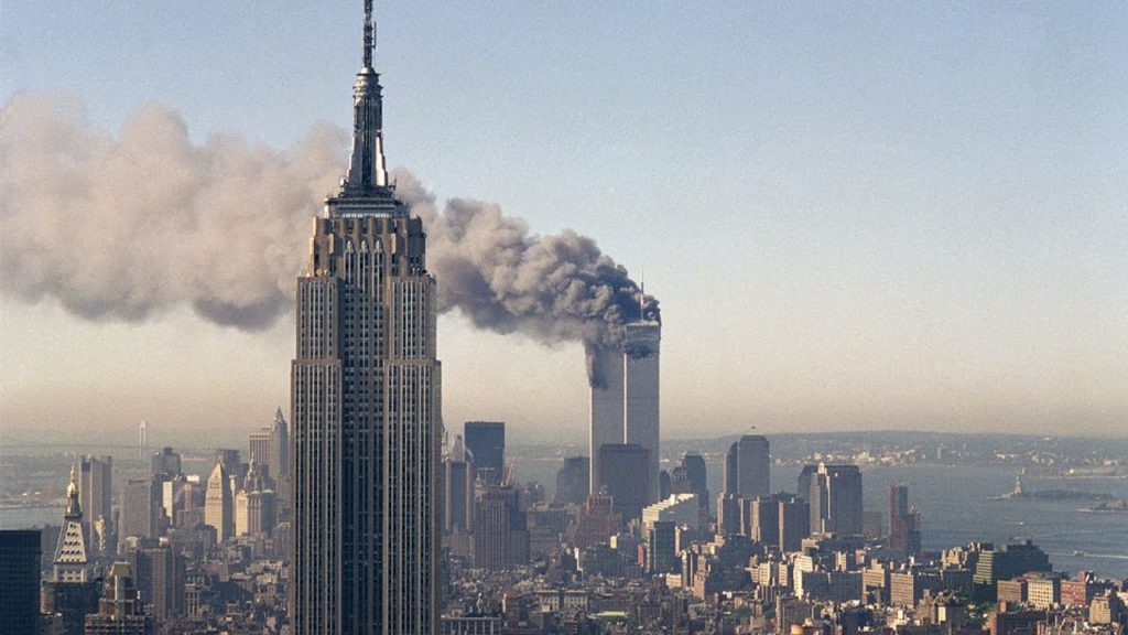 De Twin Towers in brand met op de voorgrond het Empire State Building. Foto: © Marty Lederhandler, AP
