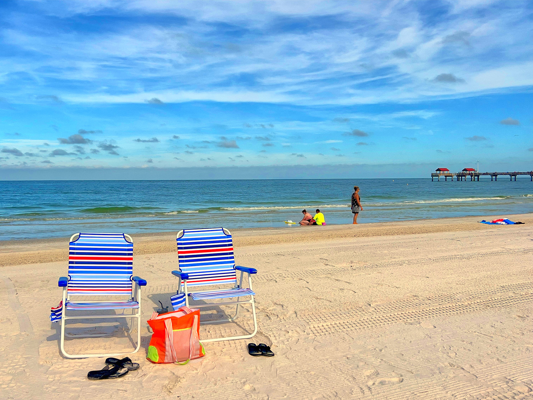 Strandstoeltjes op Clearwater Beach met op de achtergrond Pier 60 Strandstoeltjes op Clearwater Beach met op de achtergrond Pier 60